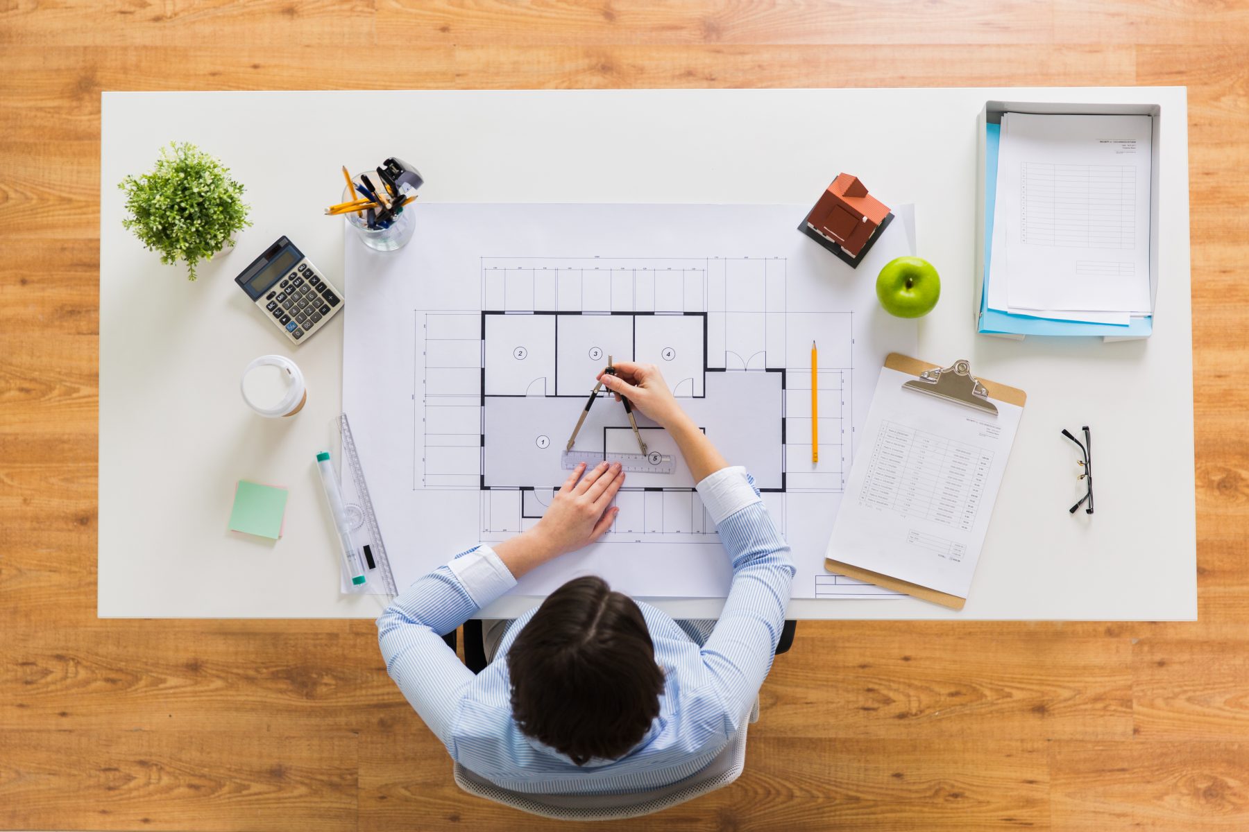 Architect measuring digital assets blueprint printout from DAM at the office. CAD drawings printout.