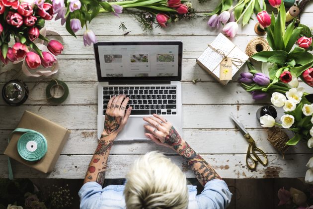 Woman browsing online flower shop product line using laptop.