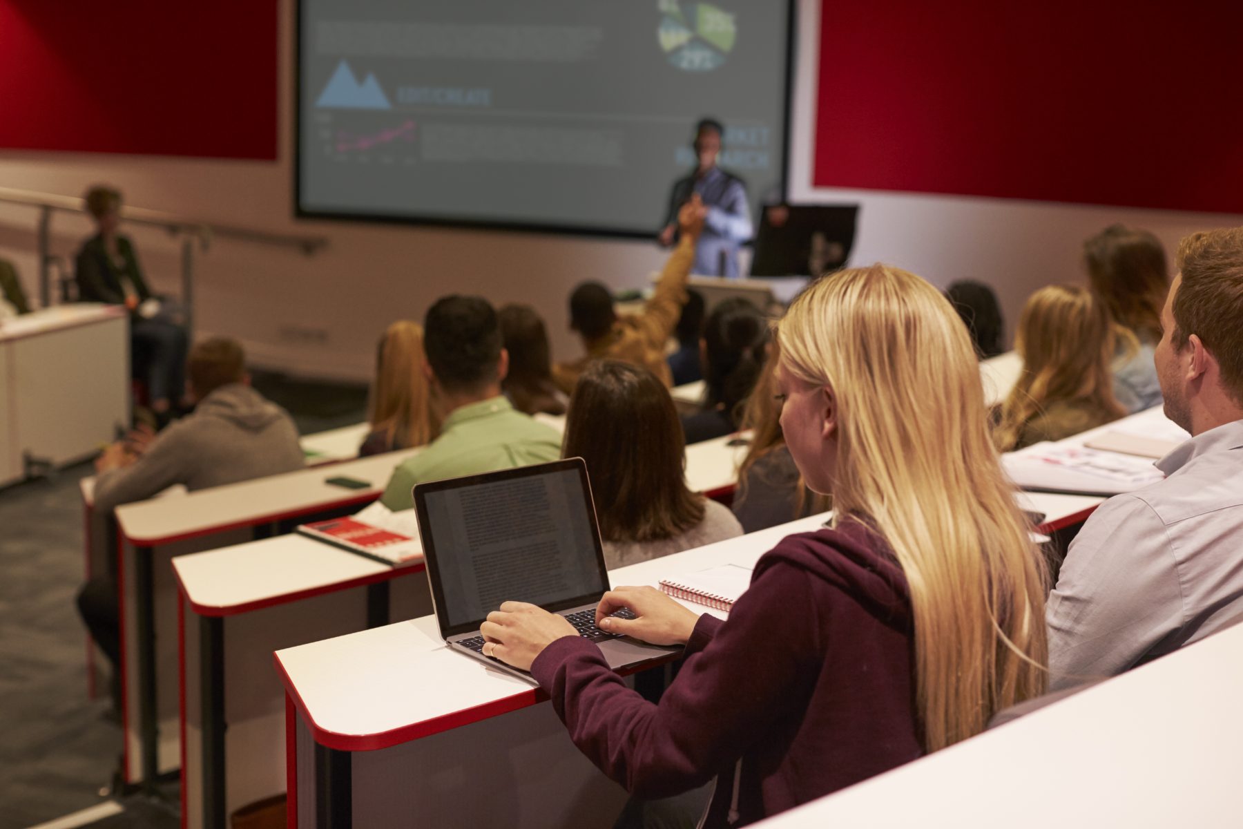 Student using laptop computer at a university lecture. Digital asset management for education.