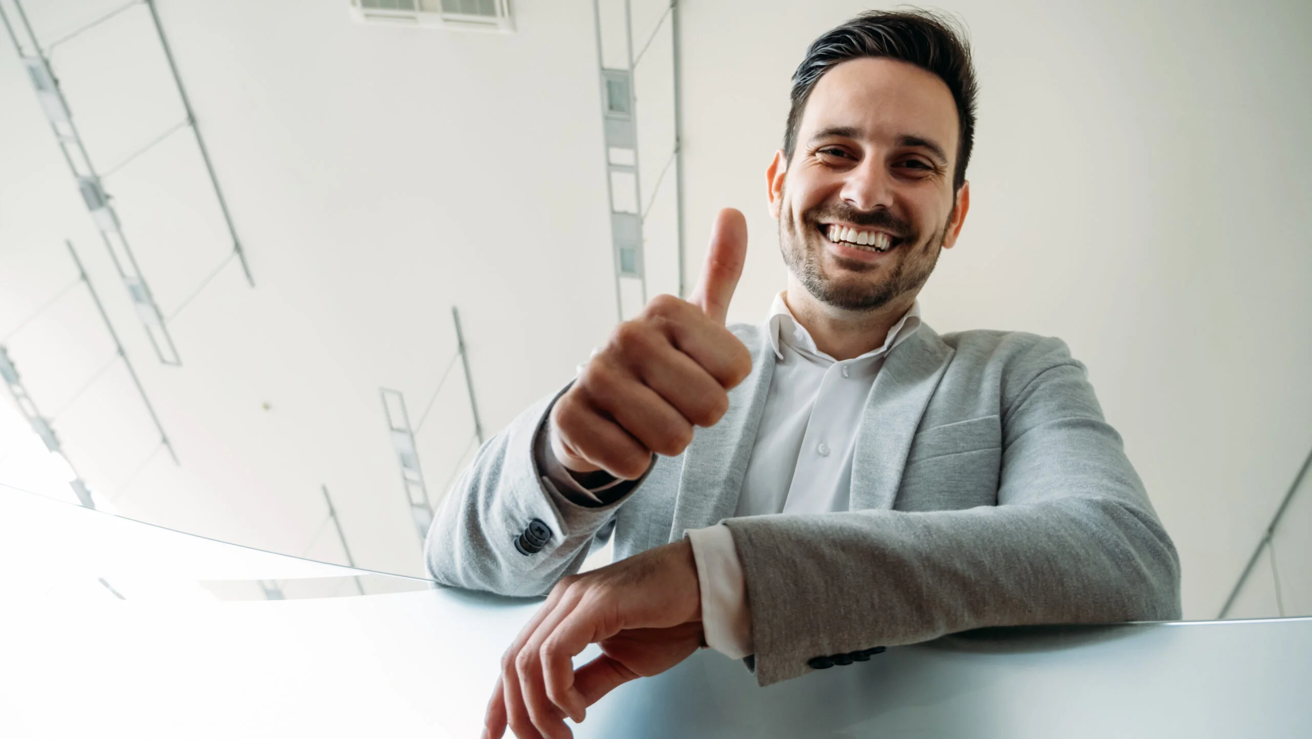 Happy smiling business man shows thumb up sign gesture. Adobe Bridge vs Daminion.
